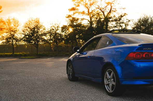 Blue Acura in an empty parking lot